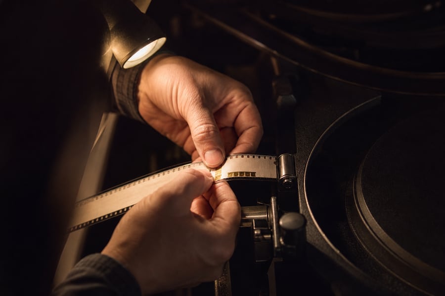A projectionist's hands threading 35mm film.